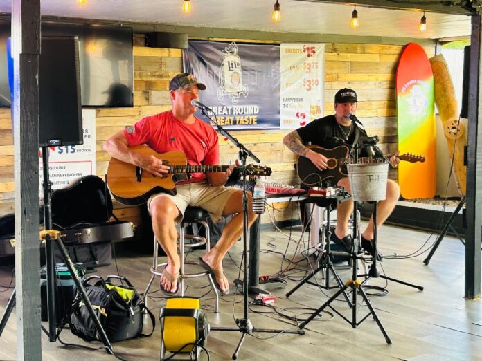 Roger Brutus and Corey Greenway playing guitars and singing